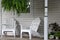 Warm and inviting image of two Adirondack chairs with potted plants on front porch