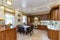 Warm and inviting kitchen with large kitchen island, cherrywood cabinets, gold granite counter tops