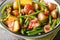 Warm jacket potato salad with bacon and green beans close-up in a bowl. Horizontal