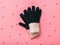 Warm knitted women`s gloves on pink background with sequins.
