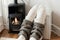 in warm knitted woolen socks near a home heater in cold winter time. The symbolic image of the heating season at home. Part of bod