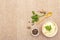 Warm mashed potatoes in a ceramic bowl with fresh parsley and dry spices. On a linen cloth background