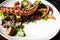 Warm octopus salad with stir fried vegetables and aji sauce on white plate. Delicious healthy mediterranean traditional