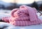 Warm pink wool scarf in the snow. Winter time. AI generated