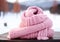 Warm pink wool scarf in the snow. Winter time. AI generated