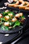 Warm pumpkin salad with mixed leaf of arugula, chard, in on black slate plate on black background. Grilled pumpkin. Close up.