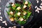 Warm pumpkin salad with mixed leaf of arugula, chard, in on black slate plate on black background. Grilled pumpkin. Top view