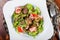 Warm salad with chicken liver, tomatoes, lettuce leaves, broccoli on wooden table. Healthy food.