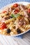 Warm salad fusilli pasta, tuna and tomatoes close up. Vertical