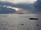 Warm sea sunset with cargo ship at the horizon . Giants cumulonimbus clouds are in the sky. Tuscany, Italy