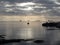 Warm sea sunset with giants cumulonimbus clouds in the sky , cargo ships at the horizon and a fishing boat going out to sea