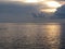 Warm sea sunset with little fishing boat on the water . Giants cumulonimbus clouds in the sky and sun rays through . Tuscany, Ital