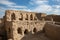 Warm sunlight on ruin in old town of Manah, Oman under cloudy blue sky