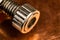 A warm toned macro image of a heavy duty machine thumb screw with an allen wrench hole in the front of it,