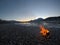 Warming fire on frozen cold white river shore