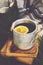 Warming tea with lemon in metal mug, books and checked plaid