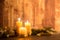 The warmth of the Christmas concept: three candles lit with cross screen stars effect on a dark wooden table with pine branches,