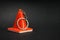 Warning of danger, traffic cone in the form of a keychain on a black background. Trinket cone on a black background with