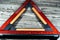 A warning foldaway reflective road hazard warning triangle isolated on wooden background, a safety measure when a car with a