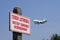 Warning sign Airport Area - Admission Strictly prohibited, landing plane in the background