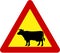 Warning sign with cattle on road