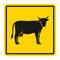Warning sign for cattle on the road. Silhouette of cow on yellow background
