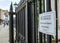 Warning sign for cyclists, seen attached to wrought iron fencing seen in a English university city.