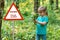 Warning sign: danger pollen allergy. little girl in the forest with a bouquet of lilies of the valley