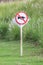 The warning sign do not use vehicle horn with flowering grass ba