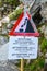 A warning sign about falling stones in the mountains