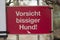 Warning sign on a gate to warn in the german language for a biting dog who guards the premisis