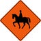 Warning sign with horse riders on road