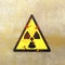 Warning sign indicating the presence of a radioactive area, nuclear site, sign hanging on a wall