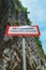 Warning sign in the mountains about the rockfall. Translation from Russian: Caution Falling stones