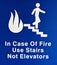 Warning sign next to elevator showing in case of fire use stairs not elevators