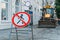 Warning sign No Entry at background of road works in city with yellow bulldozer