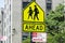 Warning sign of pedestrians crossing road ahead near school