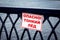 Warning sign on the railing near the river. The inscription in Russian - Danger Thin ice