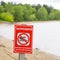 Warning sign on the river - bathing is forbidden, dangerous to l