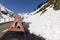 Warning sign because of a road blocked by a snow slide in the Alps