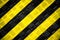 Warning sign yellow and black stripes background painted steel checker plate diamond plate on the floor as texture background