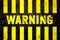 Warning sign with yellow and black stripes painted over cracked concrete wall coarse texture background