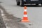 Warning traffic road cone set on asphalt street road during road repairing, asphalt pavement works on automobile highway