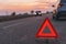 Warning triangle sign on the road in sunset