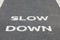 A warnning sign SLOW DOWN painted on the bike lane