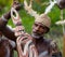 Warrior Asmat tribe sits and carves a ritual statue.