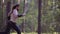 A warrior with a naked torso and a cold weapon in hands, quickly running through the woods chasing someone. Frame in slow motion.
