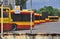 Warsaw city bus depot old rusty fence yellow red buses parked in a row in parking spaces