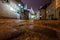 Warsaw night cityscape. Old street in Warsaw with paving stones at night in the light of street lamps.