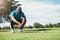 That was so close. a focused young male golfer looking at the ground while being seated on the grass outside during the